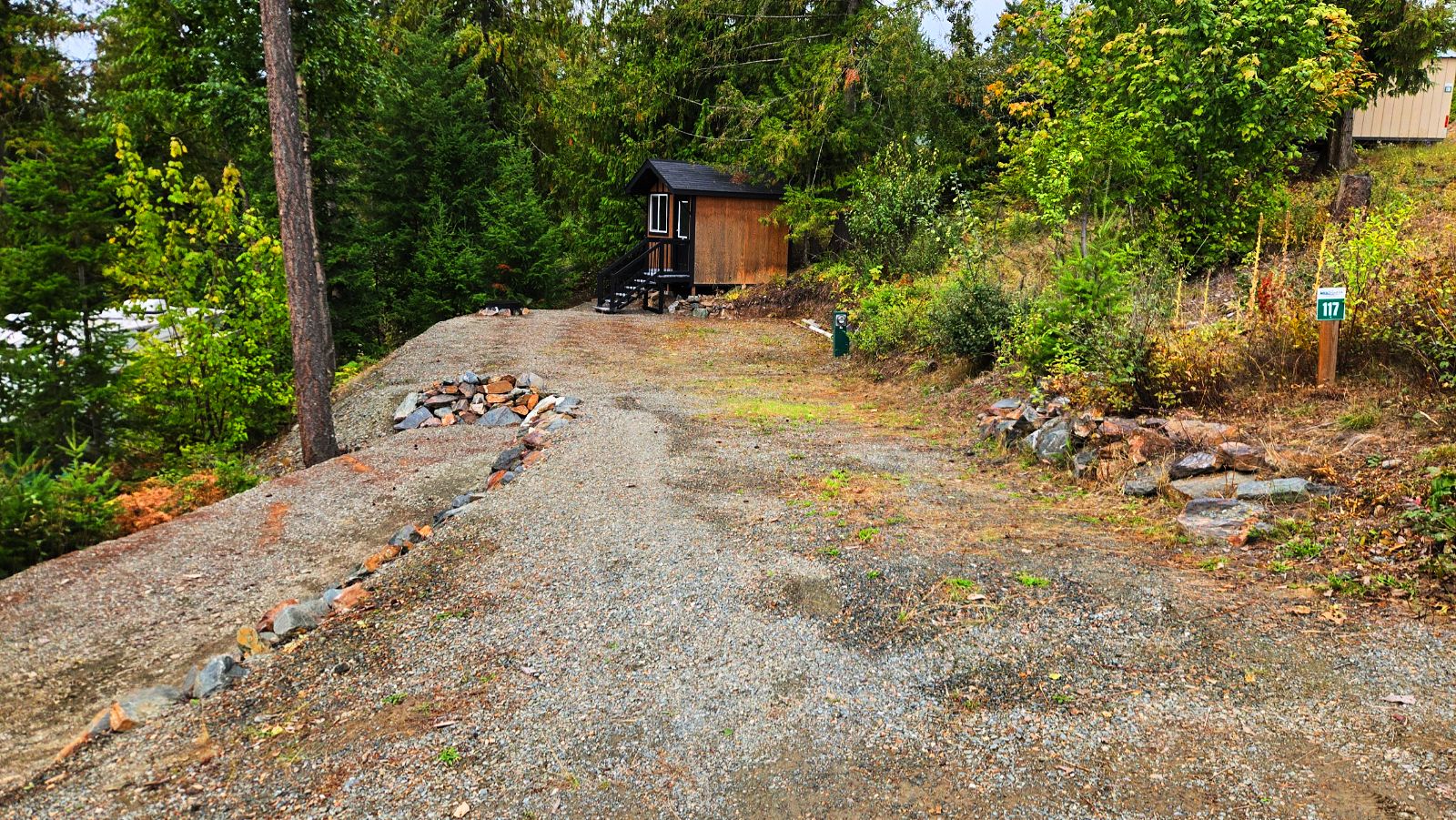 Lot 117 empty, showing the gravel pad, bunkhouse and site marker